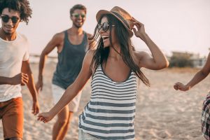 Young woman having fun on the beach with friends